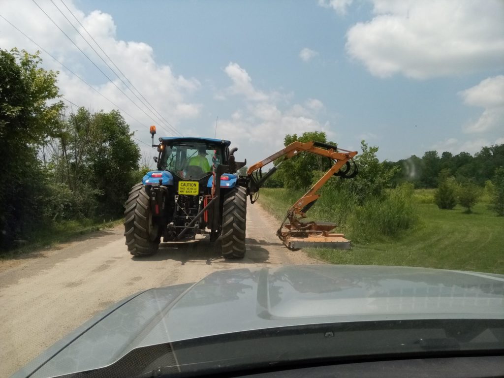 photo of an employee operating a boom mower